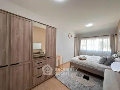 Spacious bedroom with modern wooden wardrobe and cozy decor