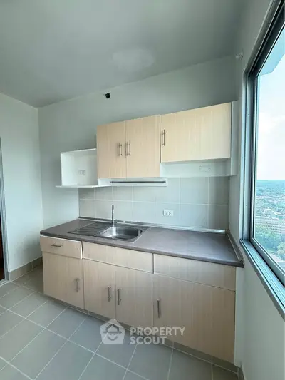 Modern kitchen with sleek cabinetry and city view window
