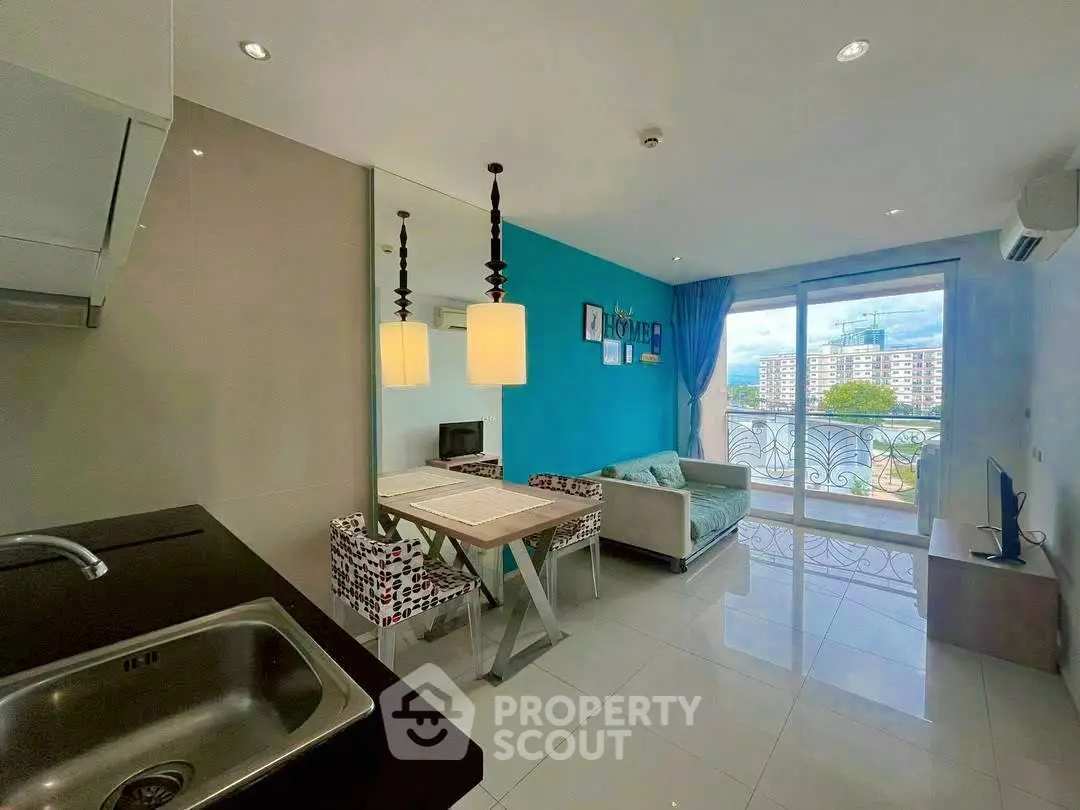 Modern living room with open kitchen and balcony view in a stylish apartment.