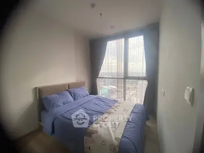 Cozy bedroom with large window offering stunning city views, featuring a comfortable bed and modern decor.