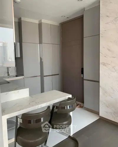 Modern kitchen with sleek cabinetry and marble accents in a stylish apartment.