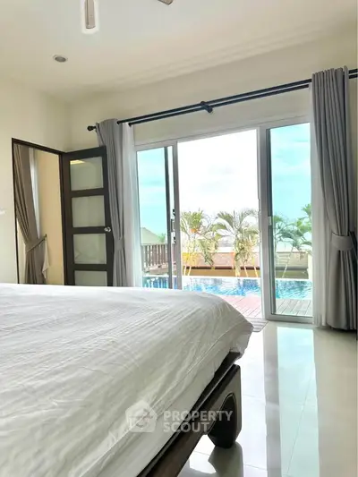 Luxurious bedroom with poolside view and elegant decor, perfect for relaxation and comfort.