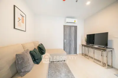 Modern living room with cozy sofa and flat-screen TV, perfect for relaxation.