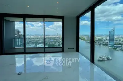 Luxurious high-rise apartment with stunning panoramic city and river views through floor-to-ceiling windows.