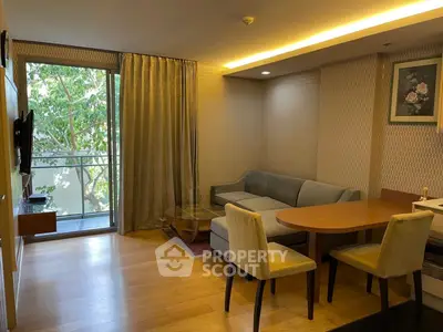 Cozy living room with balcony view, elegant furniture, and warm lighting in modern apartment.