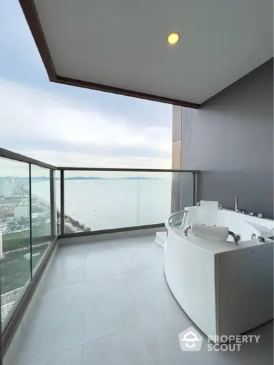 Luxurious balcony with stunning ocean view and modern bathtub for ultimate relaxation.