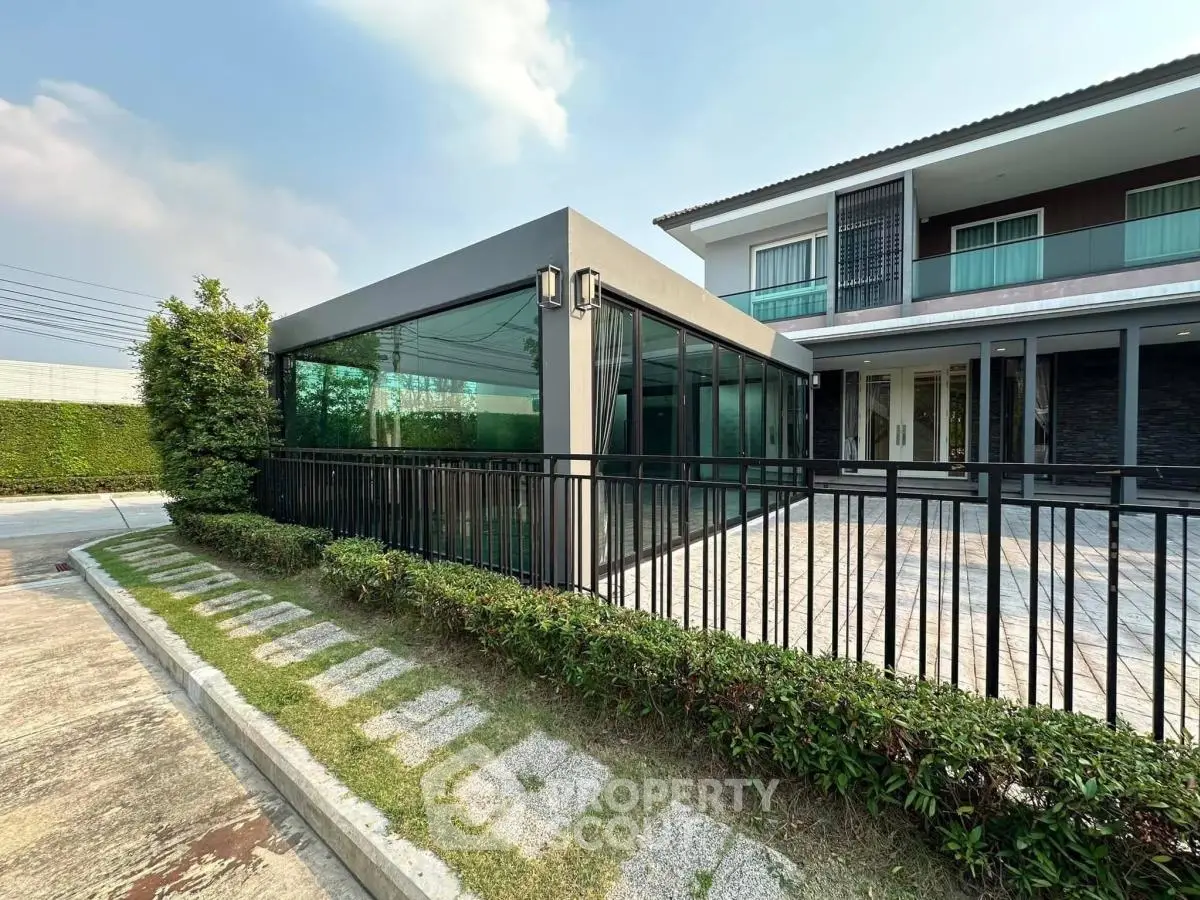 Modern two-story house with glass-enclosed patio and spacious driveway