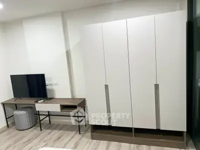 Modern bedroom with sleek wardrobe and TV stand, perfect for stylish living.