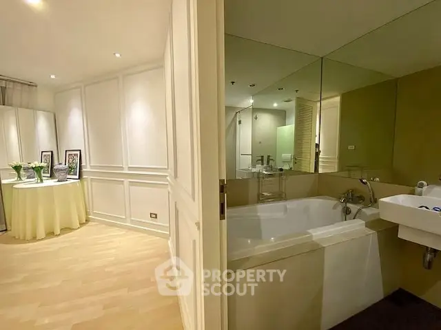 Elegant bathroom with bathtub and adjacent stylish living area in modern apartment.