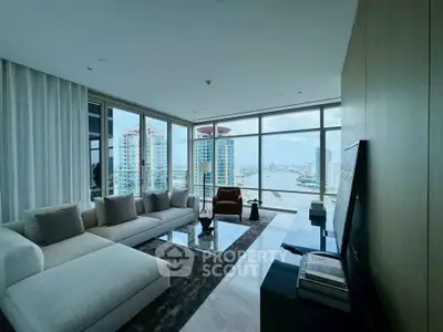 Luxurious living room with stunning river view and modern furnishings in high-rise apartment.