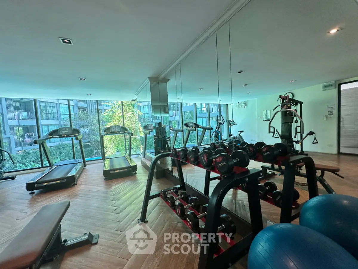 Modern gym with state-of-the-art equipment and large windows offering a scenic view.