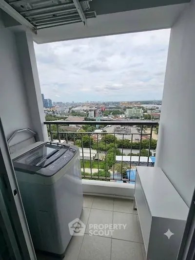 High-rise balcony with washing machine and stunning city view, perfect for urban living.