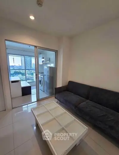 Modern living room with city view and washing machine in balcony area.