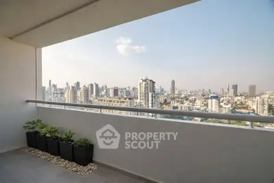 Stunning cityscape view from a modern balcony with sleek railing and potted plants.
