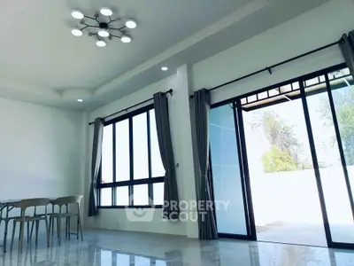 Spacious modern living room with large windows and elegant lighting