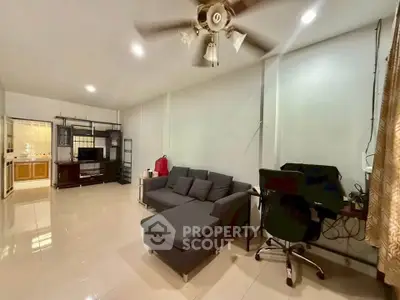 Spacious living room with modern furniture and ceiling fan, ideal for comfortable living.