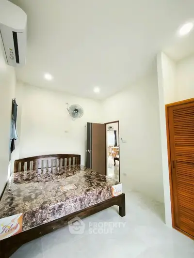 Cozy bedroom with wooden bed frame and modern air conditioning unit