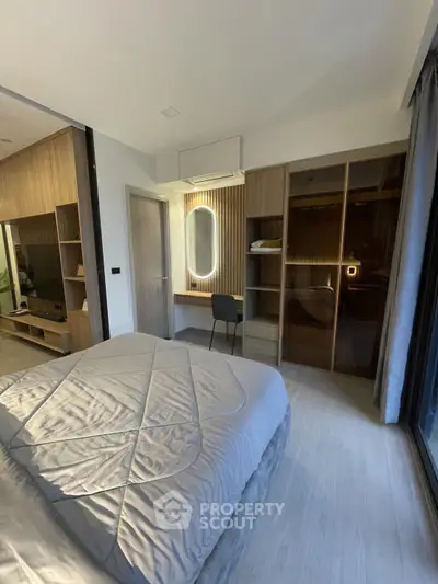 Modern bedroom with stylish decor and ample natural light, featuring a cozy bed and sleek built-in wardrobe.