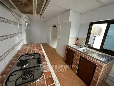 Charming kitchen with rustic tile countertops and gas stove, perfect for culinary enthusiasts.