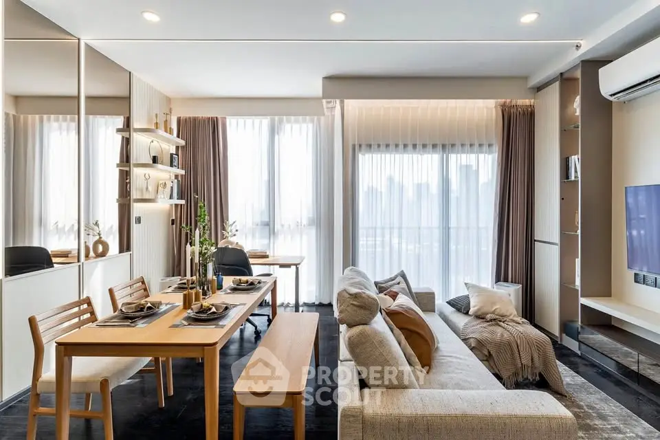 Modern living room with dining area, stylish decor, and large windows offering city views.