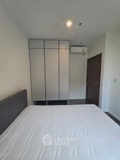 Modern bedroom with sleek wardrobe and comfortable mattress in a stylish apartment.