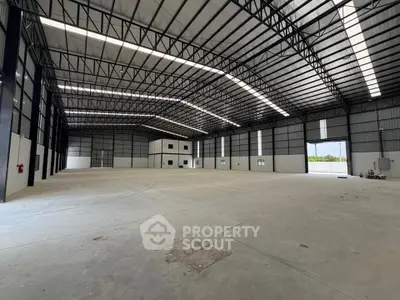 Spacious industrial warehouse with high ceilings and ample natural light.