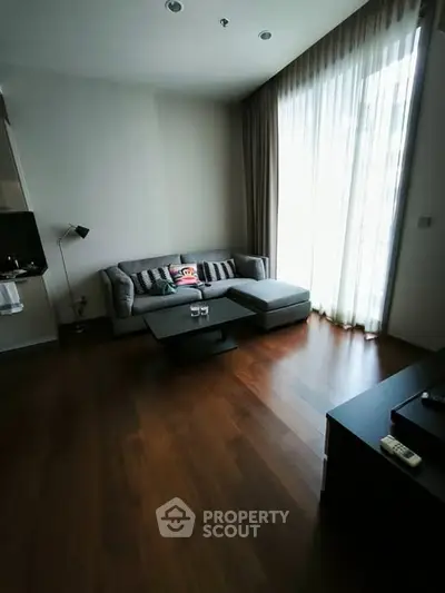 Modern living room with cozy gray sofa and floor-to-ceiling windows