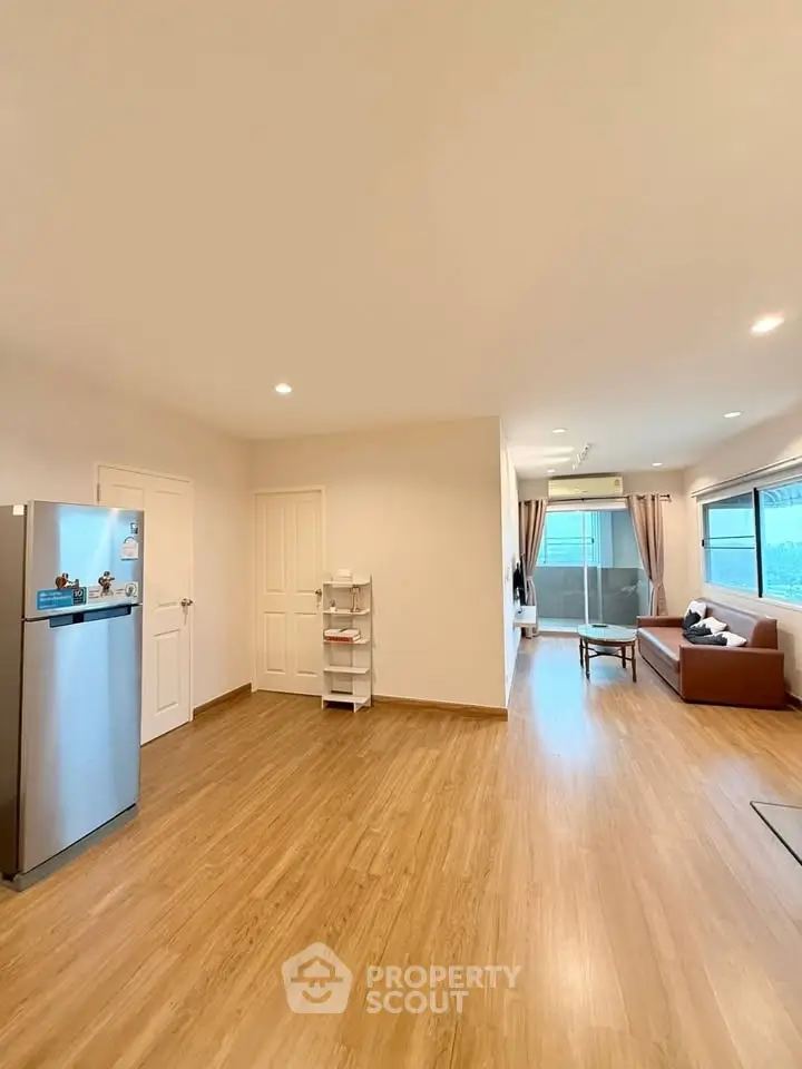 Spacious open-plan living room with modern decor and large windows for natural light.