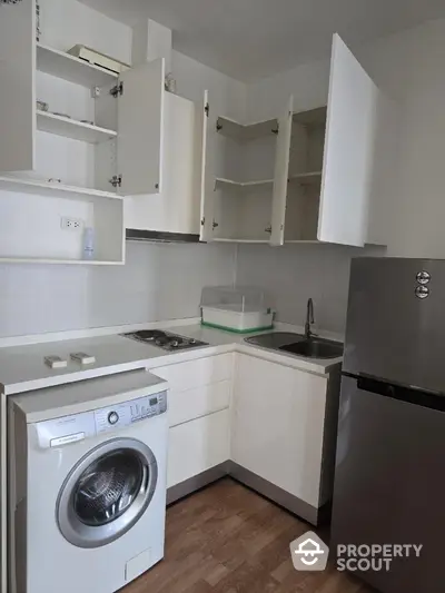 Compact kitchen with washing machine and open cabinets in modern apartment