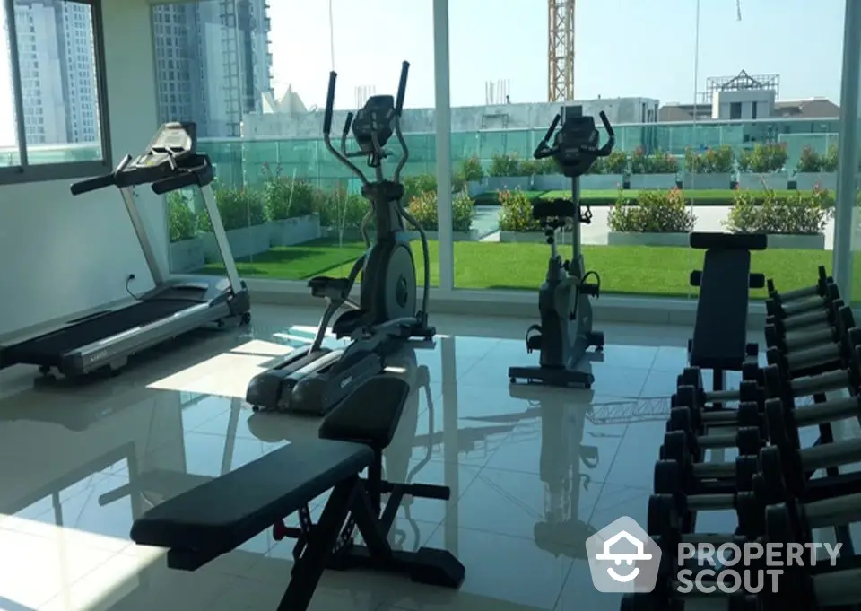 Modern gym with exercise equipment and city view in luxury apartment building