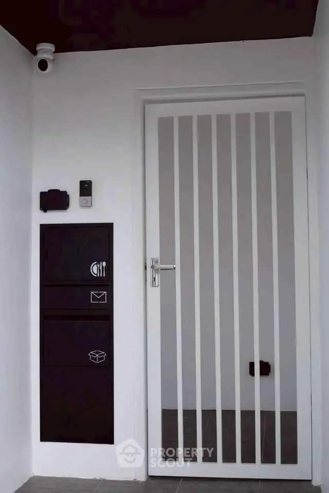 Modern entrance with sleek white door and security features