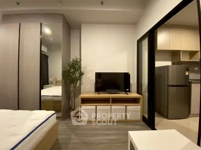 Modern studio apartment with sleek design, featuring a cozy living area and compact kitchen.