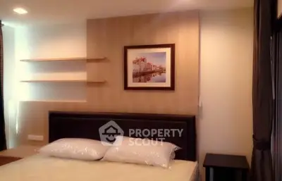 Cozy bedroom with modern decor and wall art, perfect for relaxation.