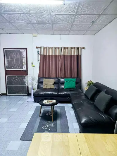 Cozy living room with modern black leather sofa and stylish decor