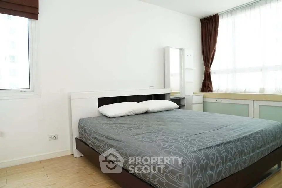 Spacious bedroom with modern design and large windows for natural light.