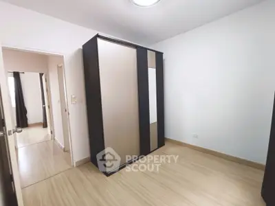 Spacious bedroom with sleek wardrobe and wooden flooring