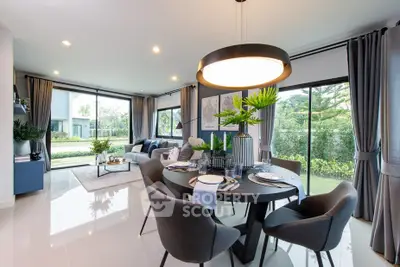 Modern open-plan living and dining area with large windows and stylish decor.