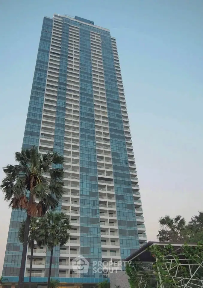 Stunning high-rise building with modern glass facade and lush palm trees.