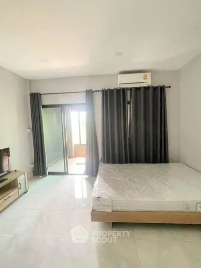 Spacious bedroom with balcony access and modern furnishings