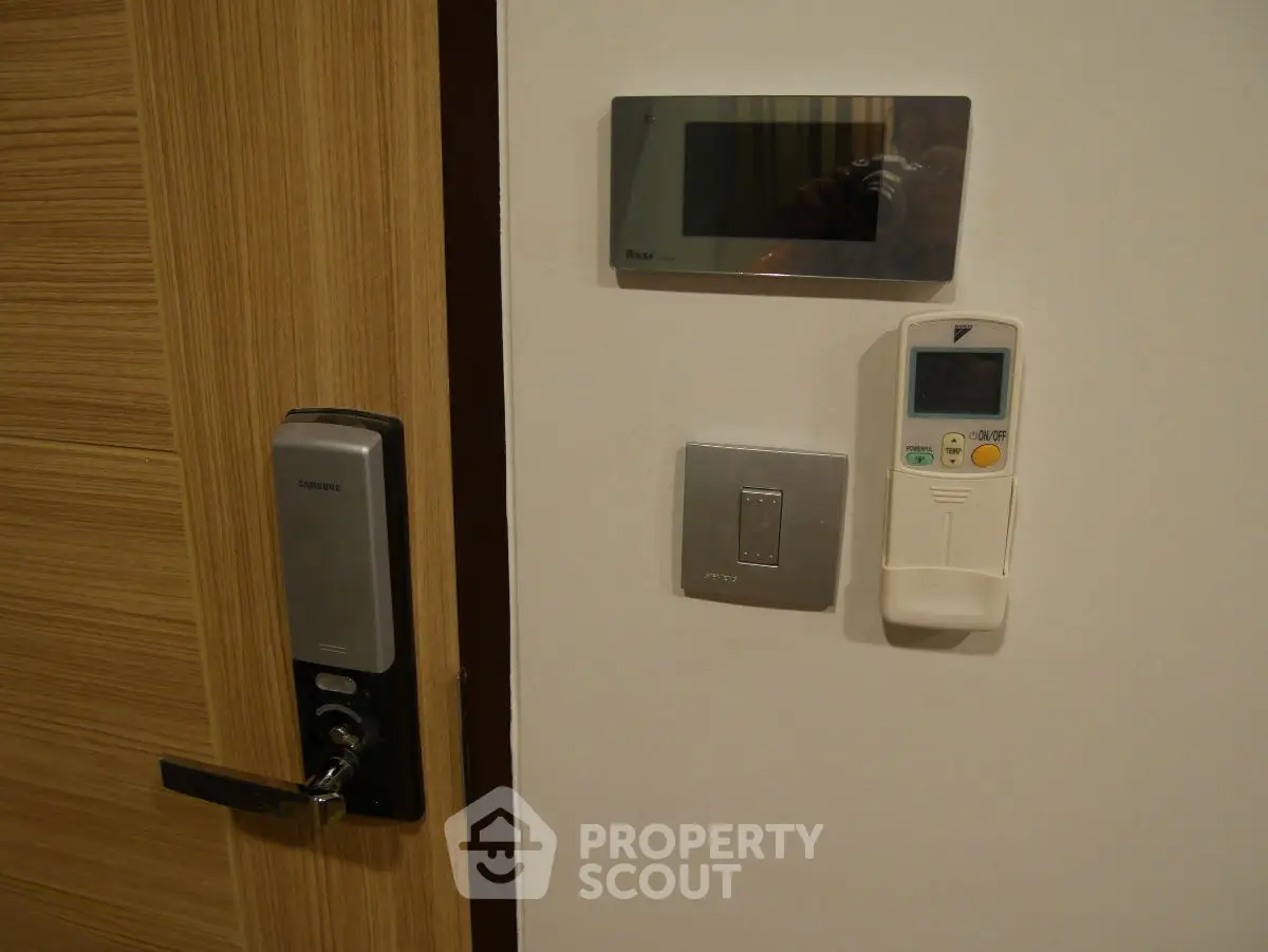 Modern apartment entry with digital lock and climate control panel.