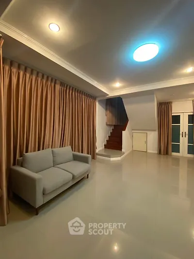 Spacious living room with modern sofa and elegant staircase in a stylish home