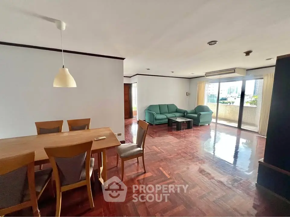 Spacious living room with wooden flooring and city view balcony in modern apartment