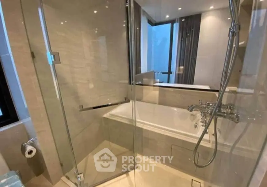 Luxurious bathroom with glass shower and bathtub in modern apartment