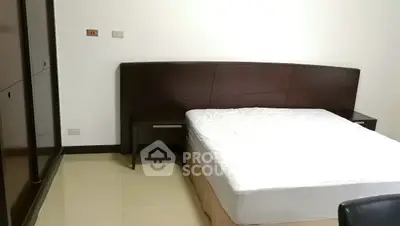 Spacious bedroom with modern bed and sleek wooden headboard in a minimalist design.