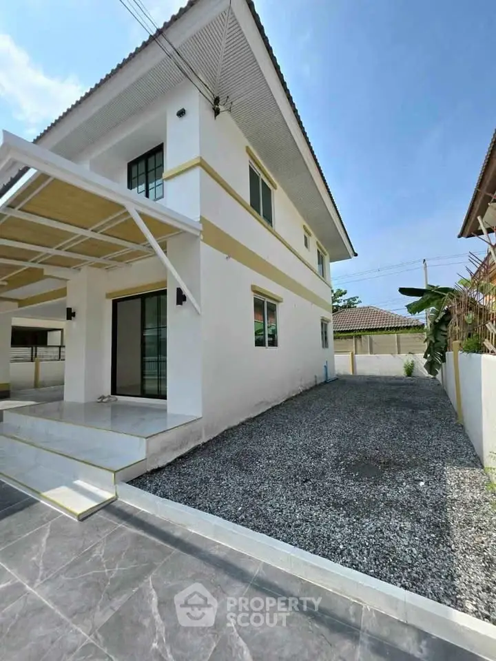 Modern two-story house with spacious driveway and sleek exterior design.
