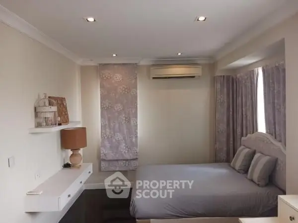 Cozy bedroom with modern decor and soft lighting, featuring a comfortable bed and stylish shelves.