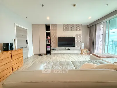 Spacious modern living room with sleek entertainment center and large windows.