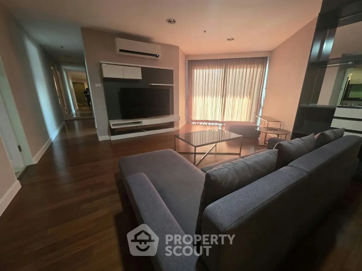 Spacious modern living room with sleek furniture and large window for natural light.