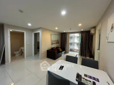 Modern living room with dining area and balcony access in a stylish apartment.