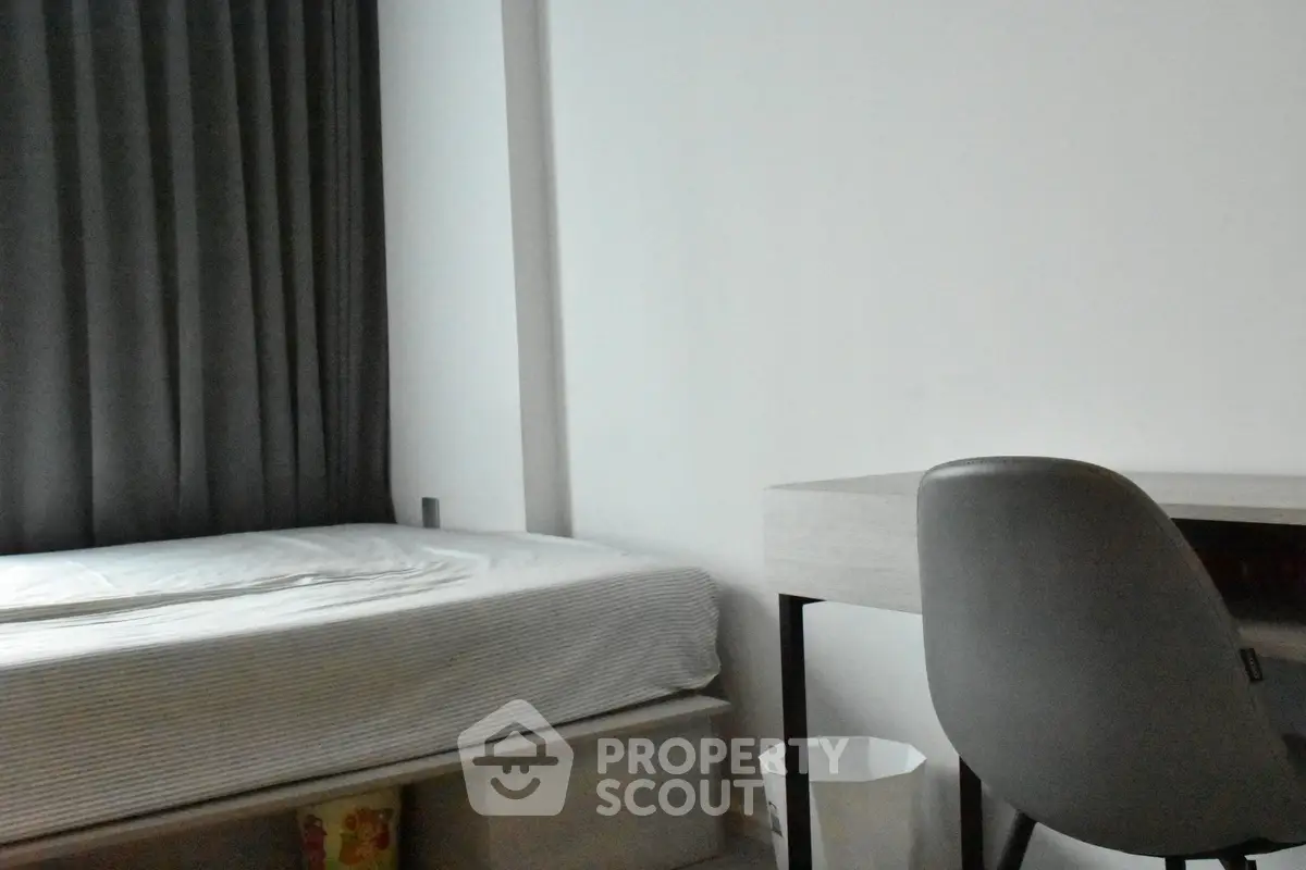 Cozy bedroom with modern desk and comfortable bed, ideal for study or relaxation.